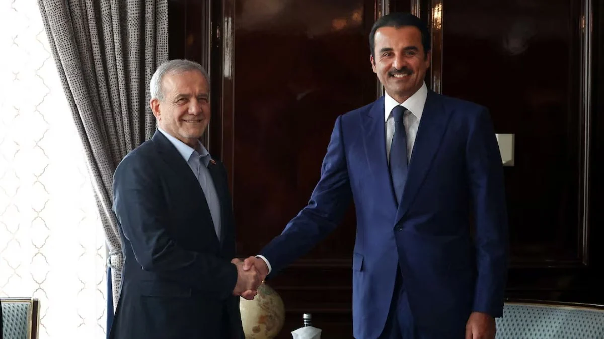 Iranian President Masoud Pezeshkian shakes hands with Qatars Emir Sheikh Tamim bin Hamad Al Thani .j