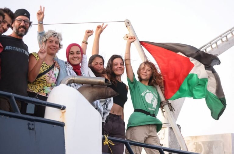Greta Thunberg and other crew members flash victory signs from their ship, part of the Global Sumud Flotilla last month. Photo: Reuters