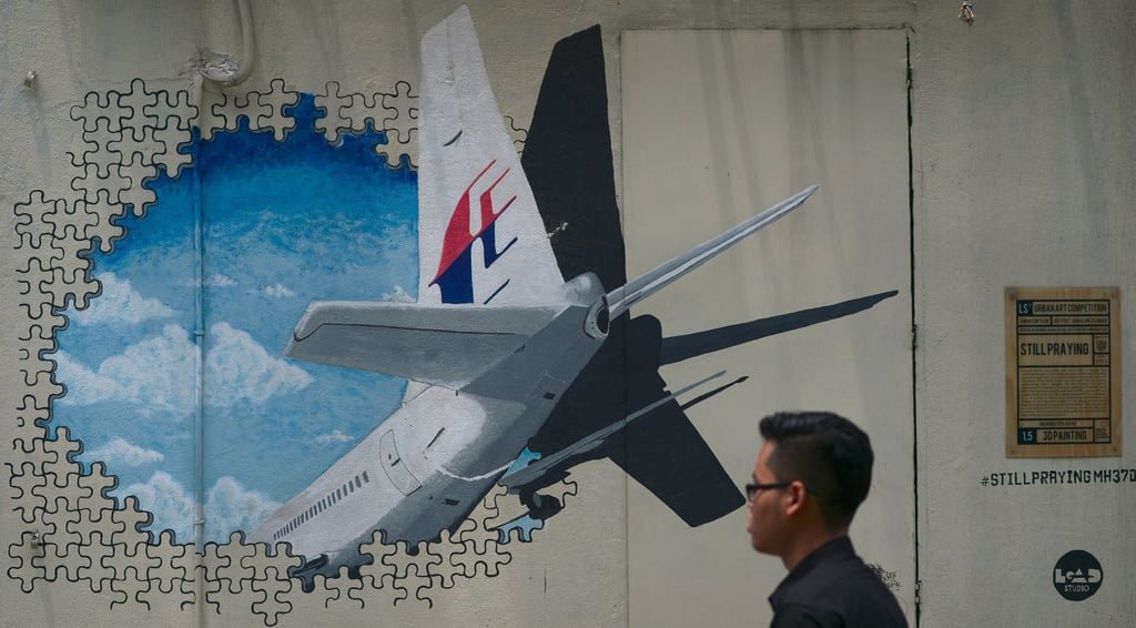 A man walks past a mural representing the missing flight MH370 in August 2015. Photo: AFP