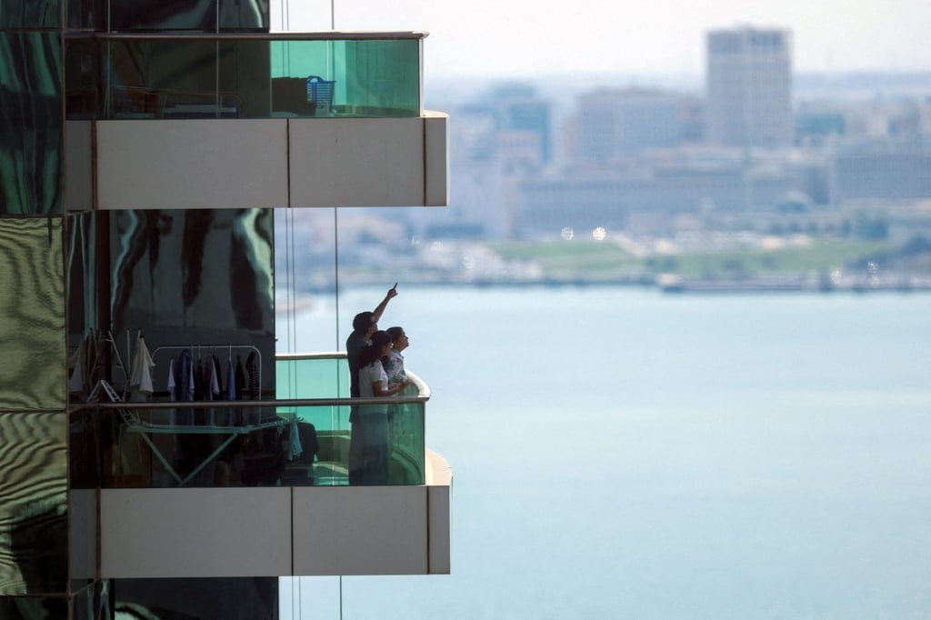 Missiles streak across Gulf skies as Iran responds to US-Israel attack 3 People watch from their balcony in Doha after Qatar’s defence ministry said it downed missiles targeting the country. Photo: Reuters
