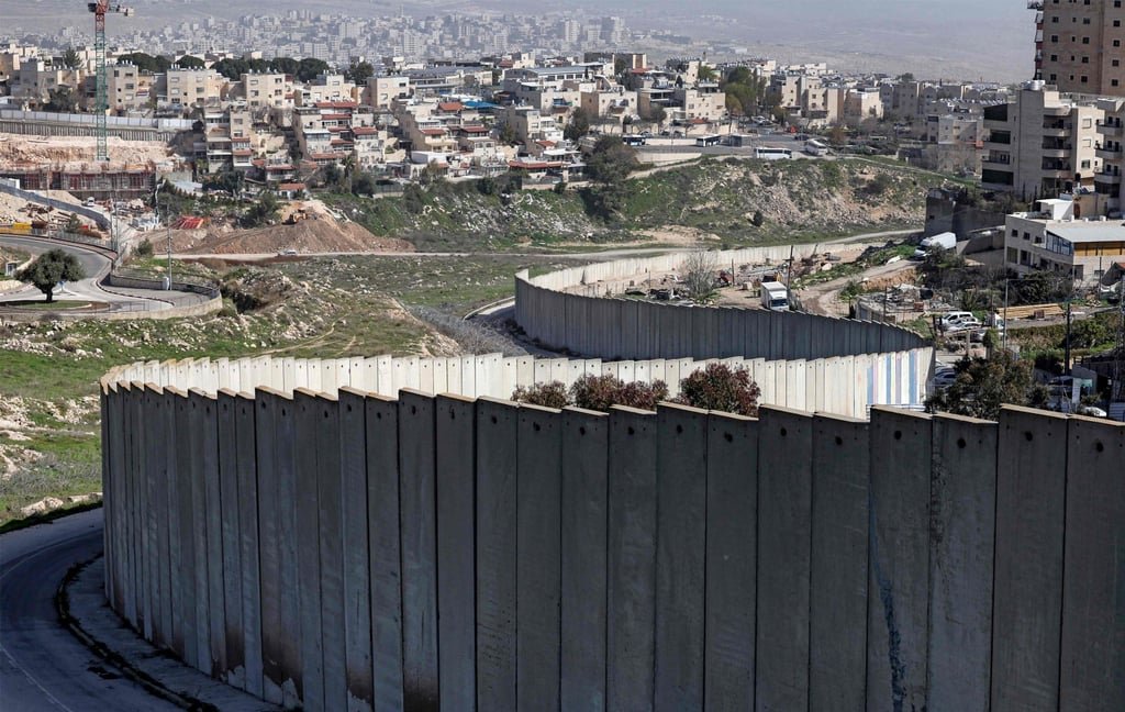 Creeping commitment? Israeli NGOs warn of plan to grow Jerusalem into West Bank 37 The Israeli settlement of Pisgat Zeev (left), built in a suburb of the mostly Arab East Jerusalem, is seen behind Israel’s separation barrier on Monday. Photo: AFP