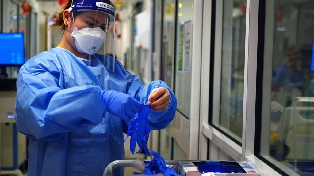 Covid inquiry PPE report - a look at the key findings 10 A nurse puts on PPE in a ward for Covid patients